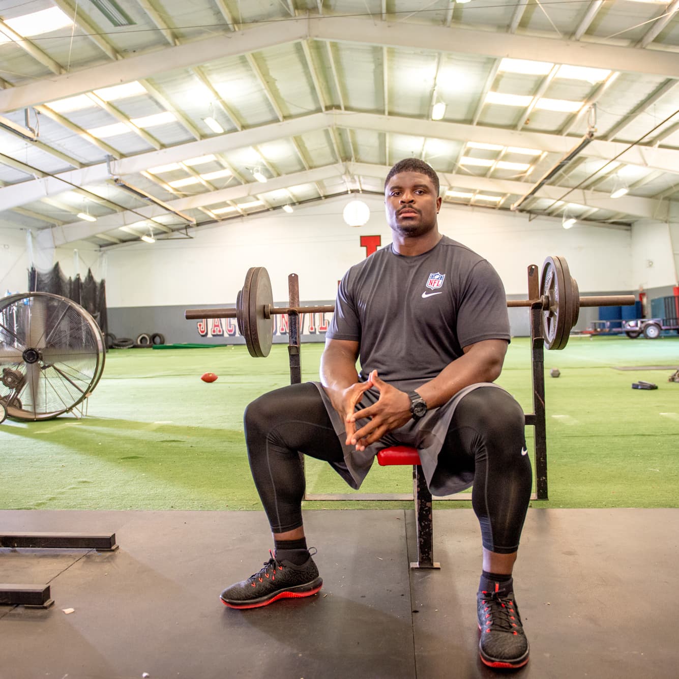 NFL athlete facing the camera in a large training facility